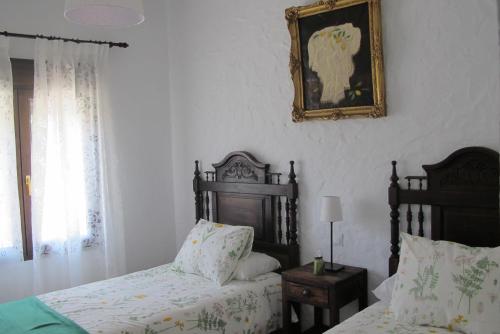 a bedroom with two beds and a picture on the wall at Casa Las Torres in Medina de las Torres