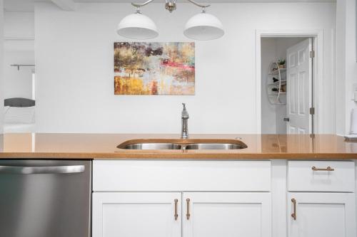 a kitchen with white cabinets and a sink at Centrally Located 3BD Urban Oasis in Indianapolis