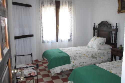 a bedroom with two beds and a window at Casa Las Torres in Medina de las Torres