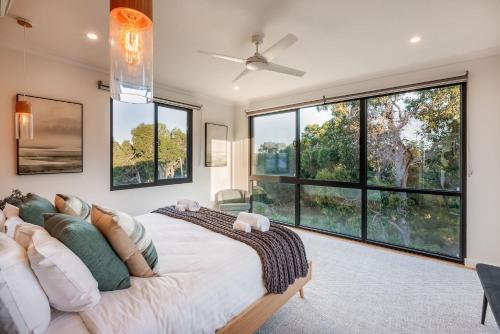 a bedroom with a large bed and large windows at Eagle Rise Plus Studio in Dunsborough