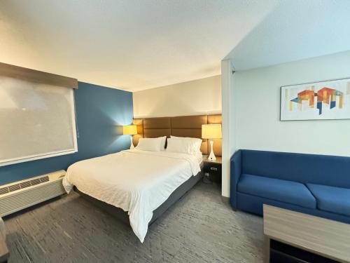 - une chambre avec un lit et un mur bleu dans l'établissement Holiday Inn Express Hotel & Suites St. Paul - Woodbury, an IHG Hotel, à Woodbury