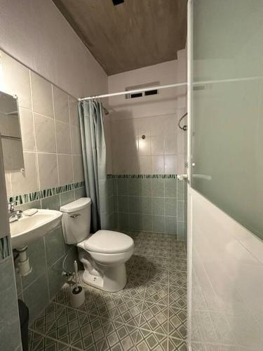a bathroom with a toilet and a sink and a shower at Brisa del Mar #2 in Brisas de Zicatela