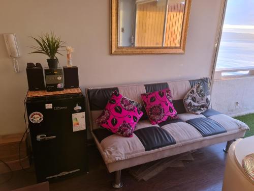 a couch with pillows on it in a living room at Departamento primera línea frente al mar in Viña del Mar
