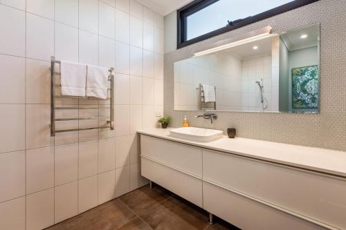 a bathroom with a sink and a mirror at Eagle Rise Plus Studio in Dunsborough