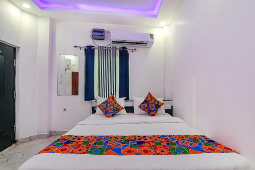 een slaapkamer met een bed met een kleurrijke deken erop bij FabExpress Hanuman Ji in Ayodhya