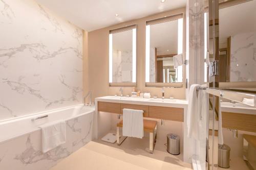 a bathroom with a tub and a sink and a bath tub at Address Dubai Opera Residences in Dubai