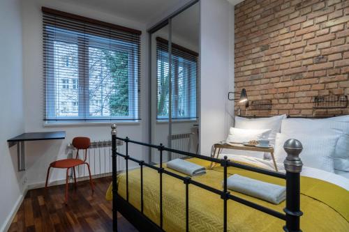 1 dormitorio con cama y pared de ladrillo en Simply in the Center Spot en Poznan