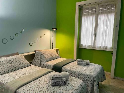 3 camas en una habitación con paredes verdes en Bilocale Lambrate/Città Studi, en Milán