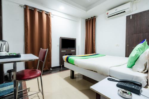 a room with a bed and a desk and a chair at Treebo Silver Apartment in Nagpur