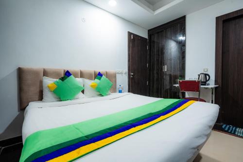 a bedroom with a large white bed with colorful sheets at Treebo Silver Apartment in Nagpur
