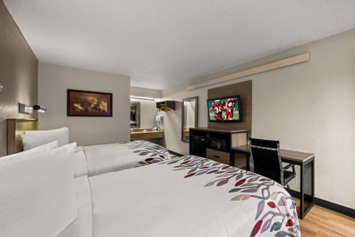 a hotel room with a large bed and a desk at Red Roof Inn Detroit - Royal Oak/Madison Heights in Madison Heights