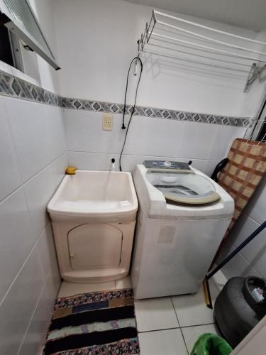 a small bathroom with a toilet and a sink at Cantinho da Ro in Balneário Camboriú