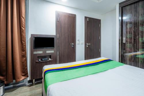 a bedroom with a bed with a rainbow blanket at Treebo Silver Apartment in Nagpur