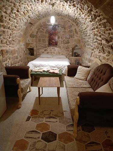 1 dormitorio con 1 cama en una pared de piedra en Acabey konuk evi en Mardin