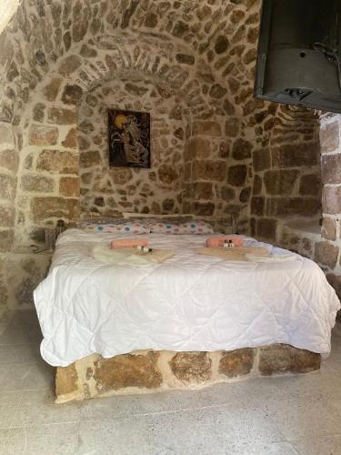 um quarto de pedra com uma cama numa parede de pedra em Acabey konuk evi em Mardin