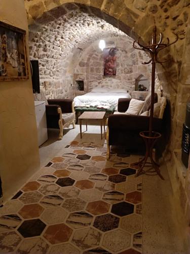 1 dormitorio con 1 cama en una habitación de piedra en Acabey konuk evi, en Mardin