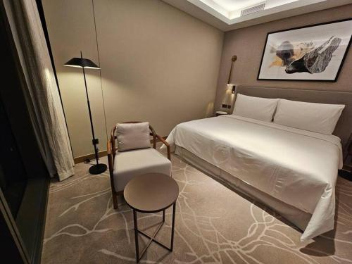 een slaapkamer met een wit bed en een stoel bij Address Residences Opera District Downtown Dubai Burj Khalifa in Dubai