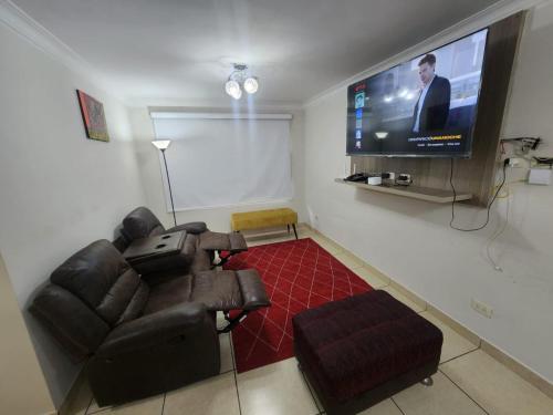 a living room with a couch and a flat screen tv at rodrich business apartment in Lima