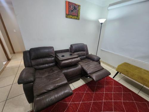 a living room with a leather couch and a table at rodrich business apartment in Lima