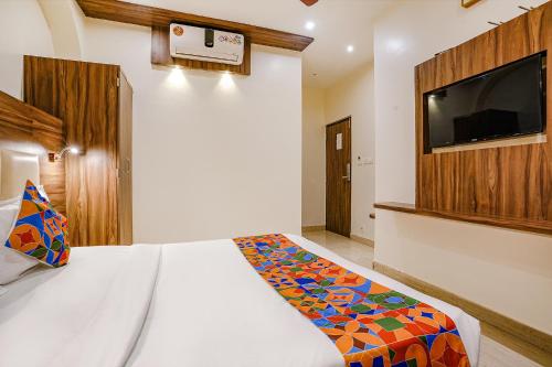 a bedroom with a bed and a flat screen tv at FabExpress Abad Inn - 700m from Gateway of India in Mumbai