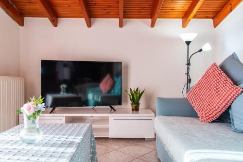 a living room with a tv and a couch at Sunset rooftop apartment in Thessaloniki