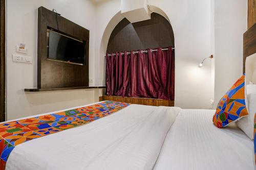 a bedroom with a white bed and a tv at FabExpress Abad Inn - 700m from Gateway of India in Mumbai