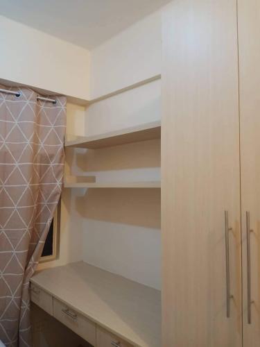 a walk in closet with white cabinets and shelves at Budget Condotel in Manila