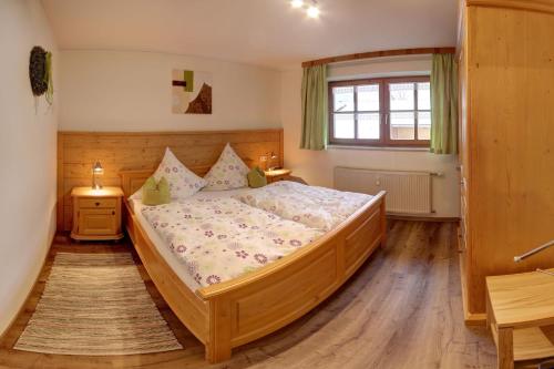 a bedroom with a large wooden bed and a window at Beim Bretzner - Chiemgau Karte in Inzell