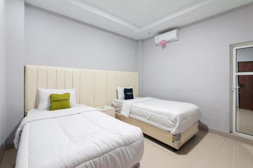 Tempat tidur dalam kamar di Urbanview Hotel Ranls Dream Banda Aceh by RedDoorz