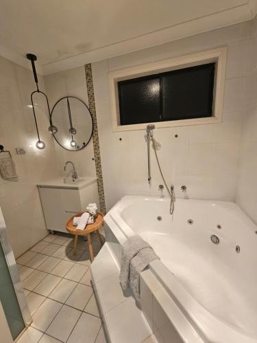 uma casa de banho branca com uma banheira e uma janela em Book a Room with a view for your stay with shared bathroom laundry kitchen and living area em Guildford
