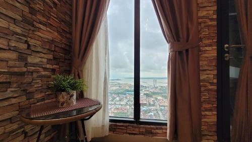 a room with a window with a plant on a table at Palam Mansion at Meisterstadt Pollux Habibie Apartment in Batam Center