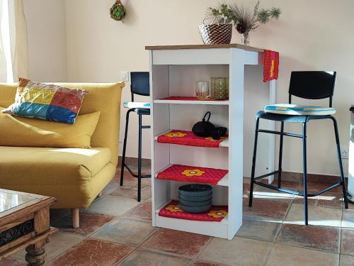 - une étagère blanche dans un salon avec un canapé dans l'établissement Petit cocon à Mourepiane, à Marseille