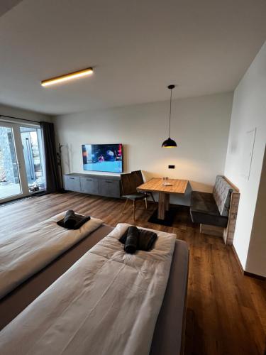- un salon avec deux lits et une table dans l'établissement Mountain Home Alpendorf, à Plankenau
