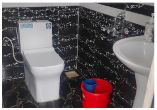 a bathroom with a white toilet and a sink at Grand Celebration Resort in Neral