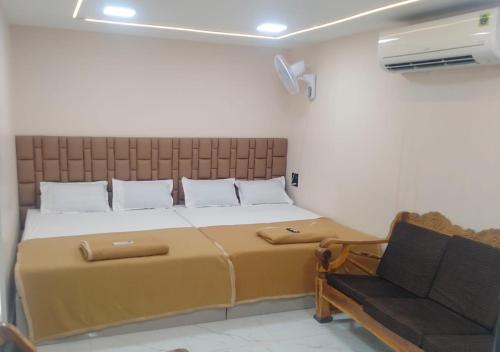 a bedroom with a large bed and a couch at Grand Celebration Resort in Neral