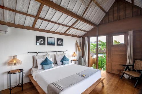 a bedroom with a large white bed with blue pillows at Villa Loma by Alfred in Bali in Seminyak