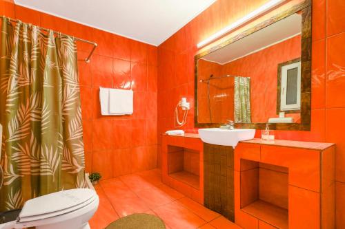 ティミショアラにあるPensiunea Venusのオレンジ色のバスルーム(シンク、鏡付)