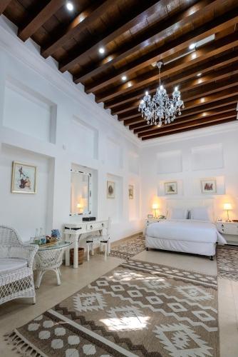 a bedroom with a bed and a table and a chandelier at Arabian Boutique Hotel in Dubai