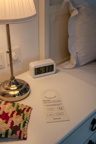a alarm clock sitting next to a lamp on a bed at Arabian Boutique Hotel in Dubai