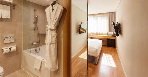 a bathroom with a shower and a bath tub at Hotel Uri& in Seoul