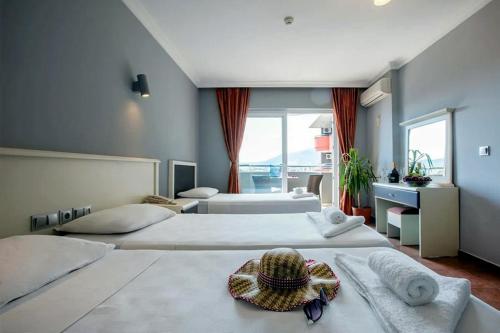 een hotelkamer met twee bedden met een hoed erop bij Grand Alisa Hotel (Ex. Royalisa Hotel) in Alanya