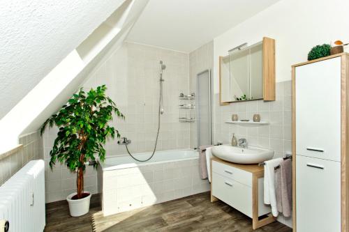 a bathroom with a sink and a bath tub with a shower at NEU! Ferienwohnung zum Wiesenblick in Toppenstedt