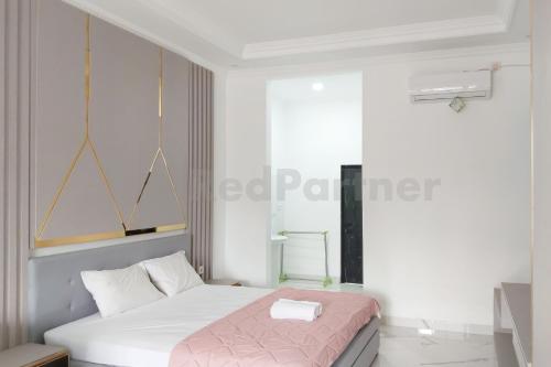 a bedroom with a bed with a pink blanket at Khayrizsan Premium Mitra RedDoorz in Cibeureum