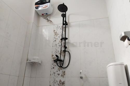 a shower with a shower head in a bathroom at Khayrizsan Premium Mitra RedDoorz in Cibeureum