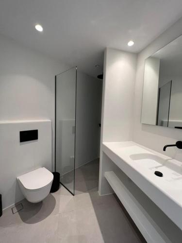 Un baño blanco con inodoro y lavabo. en Vivant Naousa Residence 2, en Naousa