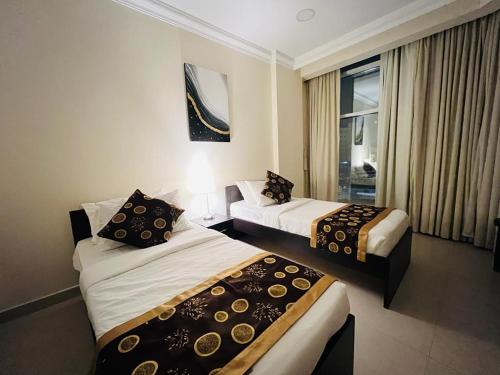 pokój hotelowy z 2 łóżkami i oknem w obiekcie Chelsea Gardens Apartment w mieście Doha