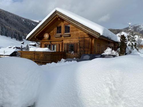 a log cabin with a pile of snow in front of it at Chalet Heidi in Bad Kleinkirchheim