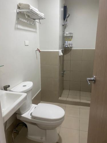 a bathroom with a toilet and a sink and a shower at Staycation at Cheers Residences in Lias