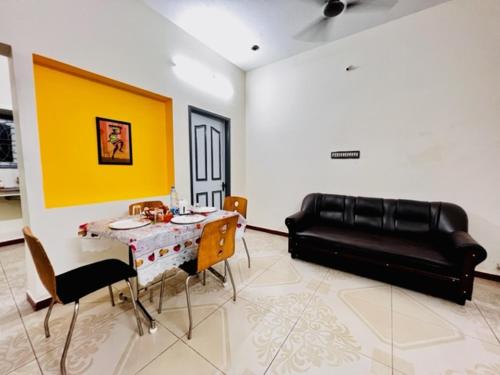ein Wohnzimmer mit einem Tisch und einem Sofa in der Unterkunft Lumina Home Stay in Puducherry