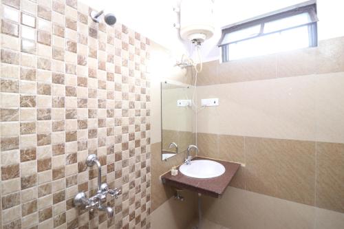 a bathroom with a sink and a mirror at Hotel Mandakini in Rudraprayāg